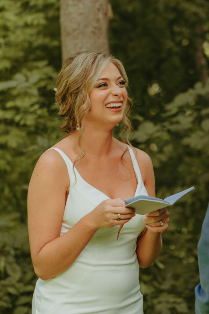 bride reading her vows and laughing