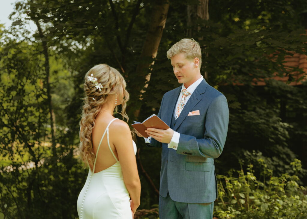 side angle of groom reading vows to bride