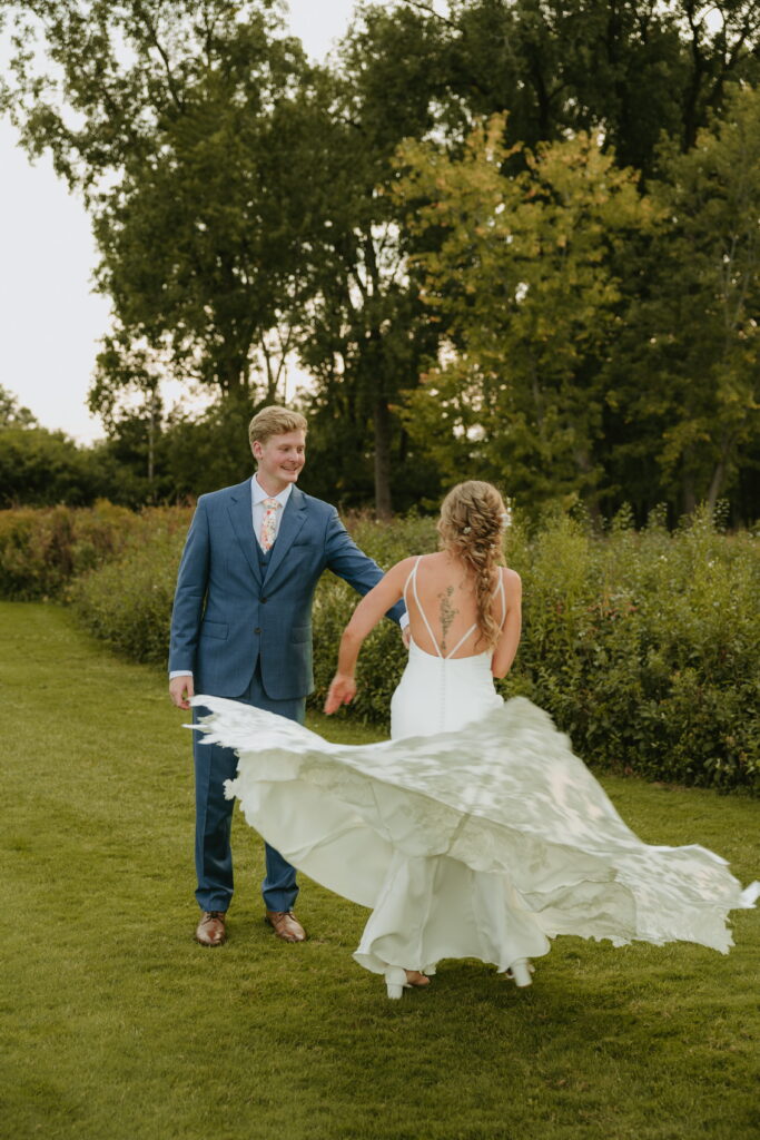morgan spinning with dress flowing in air during  golden hour couple photos at butte des morts