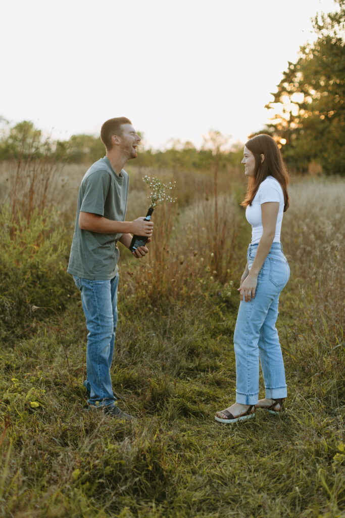 couple popped champagne for their engagement photos in a field in wisconsin