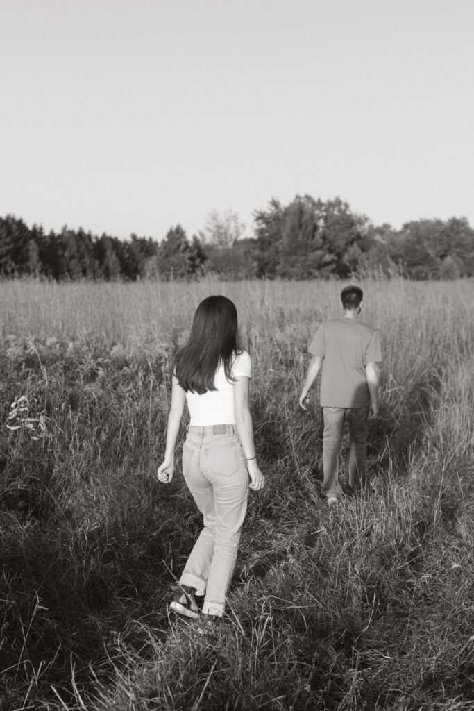 black and white couple pic, guys running away girl is slowly running towards him