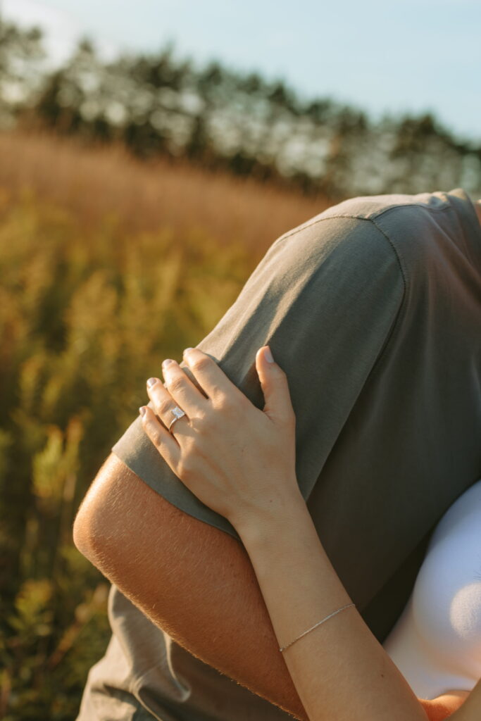 ring shot engagement photos in field close up no faces of couple