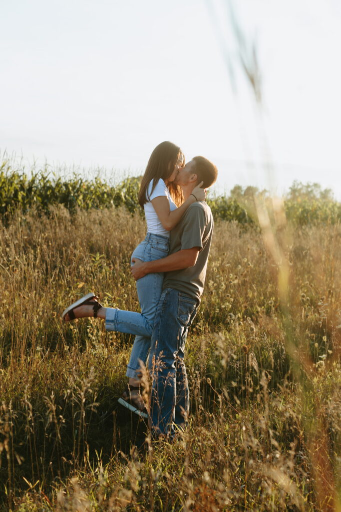 couple posing candids in field for engagement photos in wisconsin