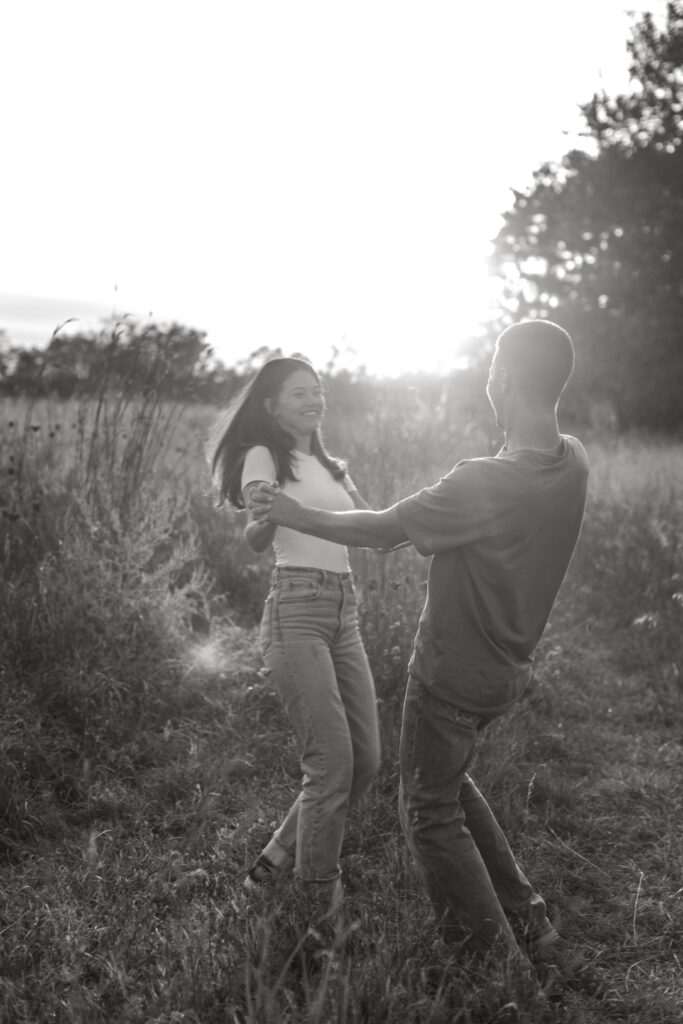 couple posing candids in field for engagement photos in wisconsin