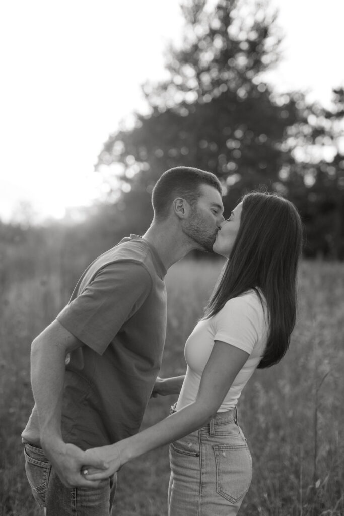 candid couple posing for field engagement photos