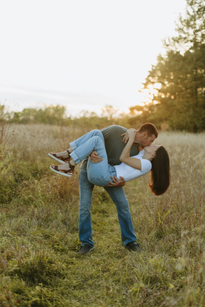 candid couple posing for field engagement photos