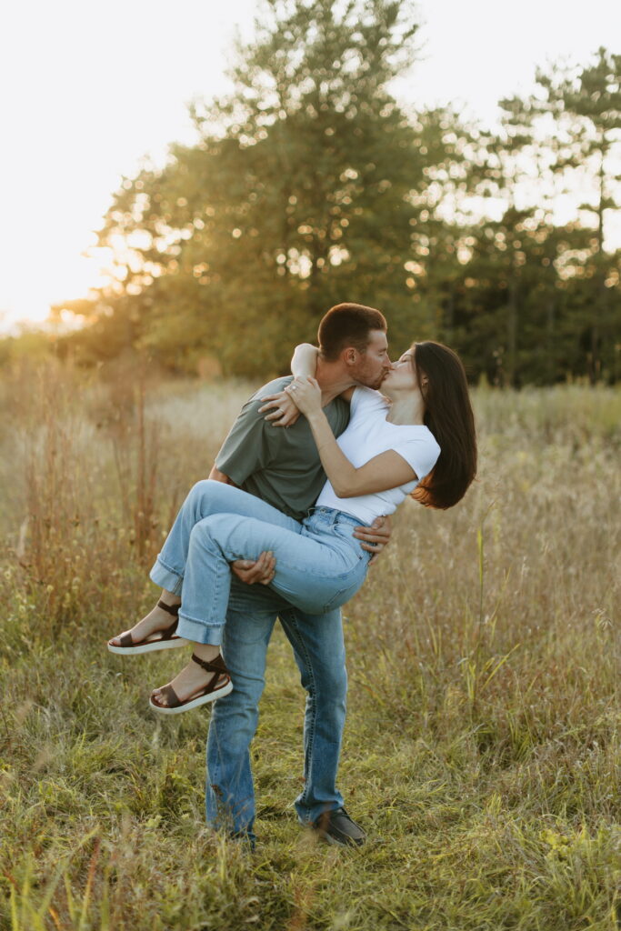candid couple posing for field engagement photos