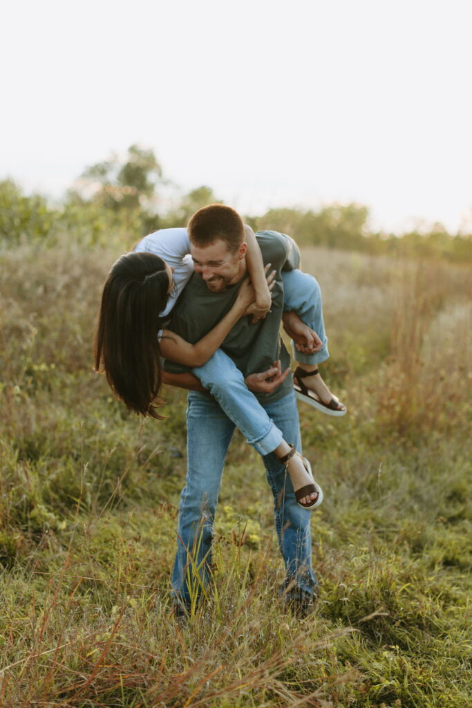 candid couple posing for field engagement photos