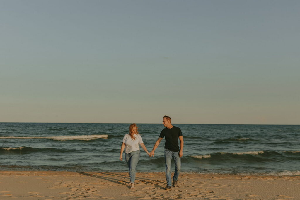 couple walking on beach at kohler andrae state park