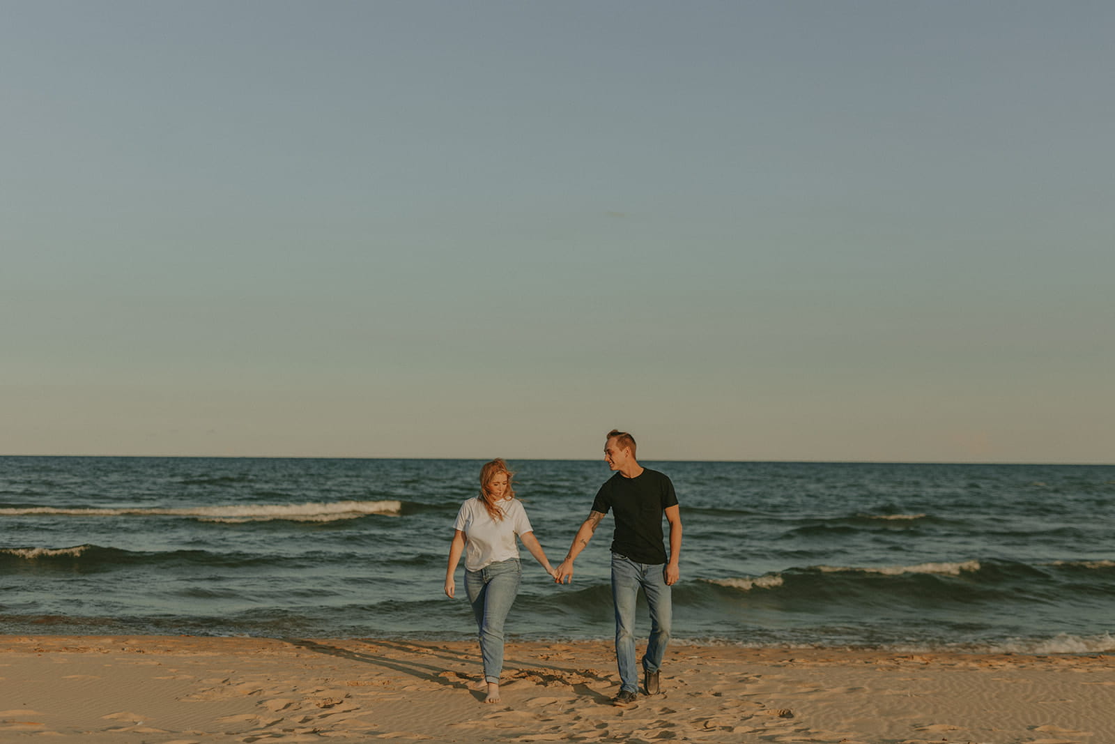 couple walking on beach at kohler andrae state park