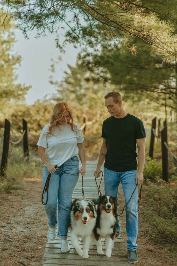 photo of couple with their dogs at kohler andrae on trail