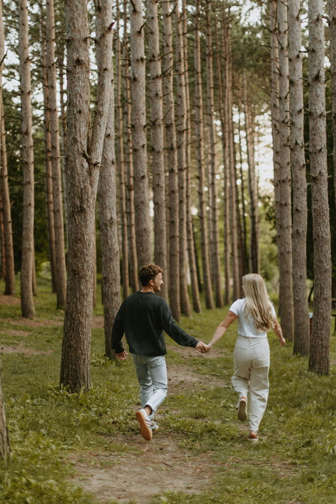 couple running away with large tall trees